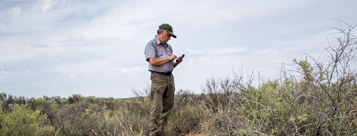National Park Service Chief of Resources and Science Bill Parker logs artifacts that were strewn from vehicles on Historic Route 66 in Petrified Forest National Park during the 1950s. The paved road no longer exists. | Jeff Kida