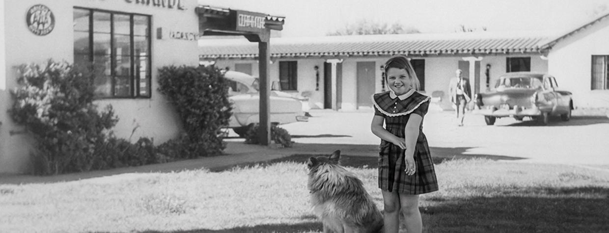 Eight-year-old Royce Kardinal, née Coxswell, and the family dog, Brenda, stand in front of the motel in Wickenburg where Royce grew up. | Courtesy Best Western Hotels