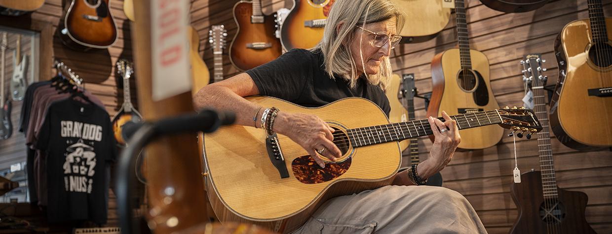 Gray Dog Music customer Julie Sullivan Brace plays one of the store’s available guitars. | Dawn Kish