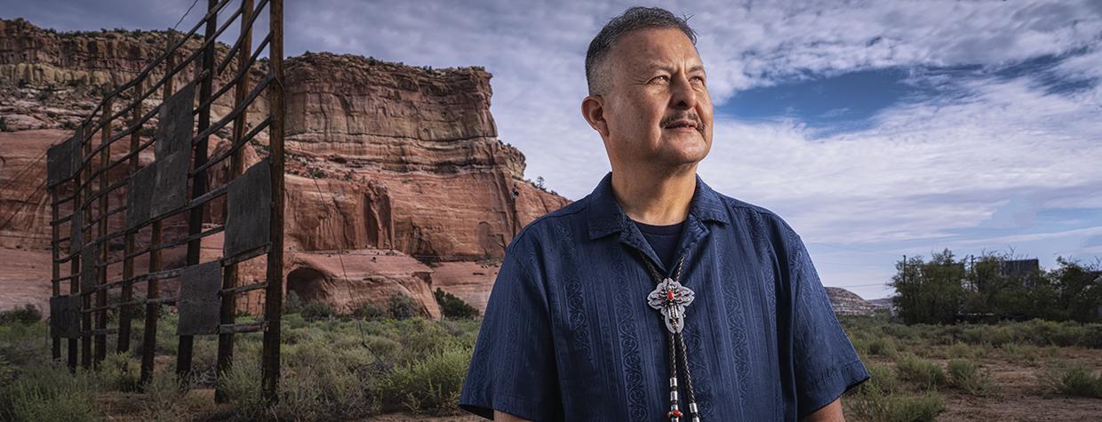 Master Diné silversmith Alvin Yellowhorse stands on the property of the former Ortega’s Indian Market in Lupton, with the Painted Cliffs behind him. | Joel Grimes