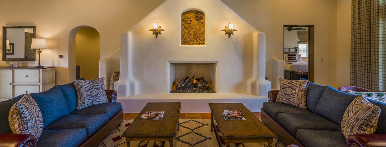The spacious interior of a suite at Ranchos de los Caballeros includes an adobe fireplace, wood beam ceilings and mirrored couches with coffee tables. | Laurence Parent