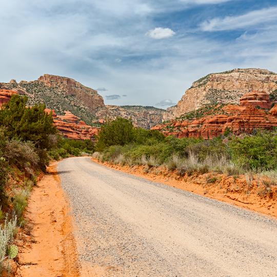 Well-maintained Forest Road 525 curves toward the sandstone buttes of Red Rock Country. By Derek von Briesen