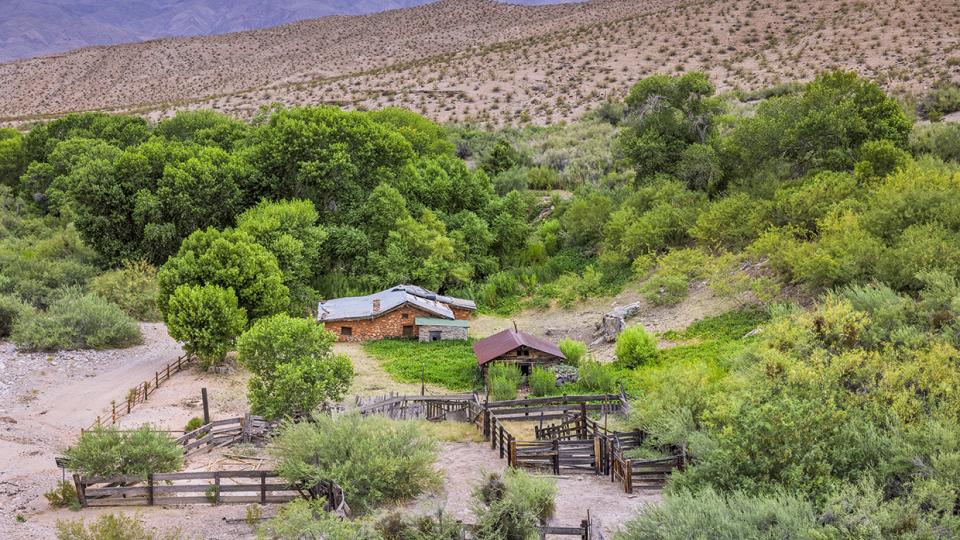 Immediately surrounded by green vegetation, Tassi Ranch sits on a rugged and remote stretch of northwest Arizona. By John Burhcam