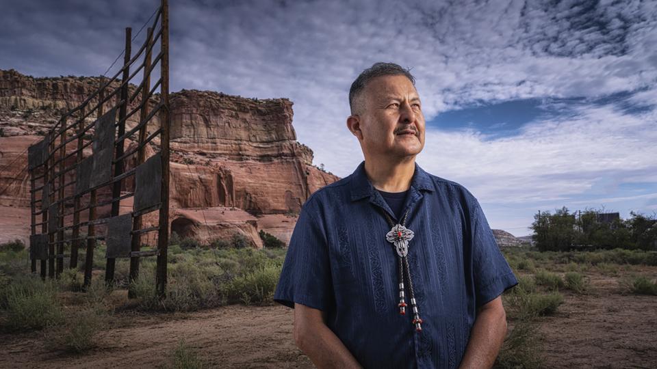 Master Diné silversmith Alvin Yellowhorse stands on the property of the former Ortega’s Indian Market in Lupton, with the Painted Cliffs behind him. | Joel Grimes
