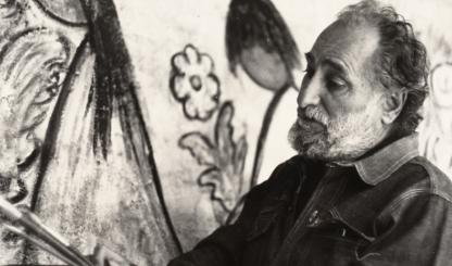 Ted DeGrazia stands with brushes and palette in front of a mural-sized painting. COURTESY OF DeGRAZIA GALLERY IN THE SUN 