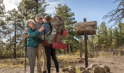 Arizona Trail thru-hiker Melina Keil, visiting from Germany, embraces “trail angels” Melody and Tim Varner on the trail near Flagstaff. Keil reached out to the Varners just a day before she was to arrive, and the couple sprang into action. | Dawn Kish