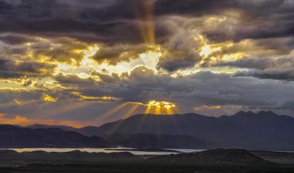 Rays of sunlight burst through dark and gloomy storm clouds at Parker Canyon. | Claire Curran