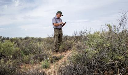 National Park Service Chief of Resources and Science Bill Parker logs artifacts that were strewn from vehicles on Historic Route 66 in Petrified Forest National Park during the 1950s. The paved road no longer exists. | Jeff Kida