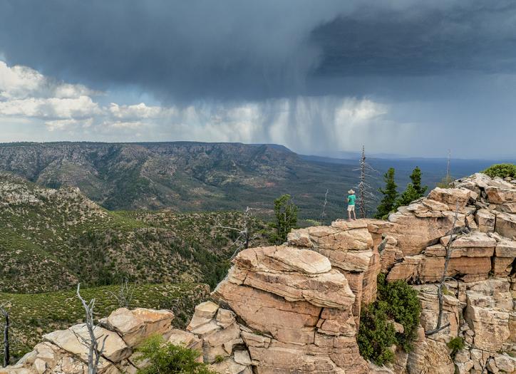 Writer Tyler Williams surveys a significant  rainstorm from the Mogollon Rim, east of Baker Butte. There, the Rim and the Arizona Divide make a sharp turn toward the east. | John Burcham