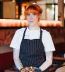 A red-headed chef displays a plate of grilled octopus in a dining room in Sedona. 