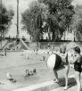 BW photo of two girls with giant beach ball at edge of the pool at Tempe Beach, which is occupied by several other people. Photograph: TEMPE HISTORY MUSEUM