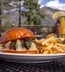 Burger, fries and beverage on patio with San Francisco Peaks in background. By John Burcham