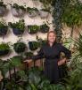 Chelsea Thomas poses amid dozens of green plants at Plantae in Flagstaff. By John Burcham