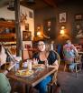 People dining at wooden tables and chairs inside the Bear & Dragon Café. By Dan Kish