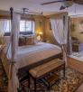 The intimate interior of a room at Kull features a poster bed, wooden floors and a separate sitting room. By John Burcham