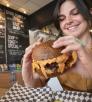 A woman prepares to take a bite of a big cheeseburger at JoeJoeBob's in Flagstaff. By Dawn Kish