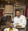 Eddie Guzman poses at Julianna's with a signature steak dish and a glass of red wine. By Paul Markow