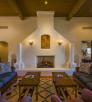 The spacious interior of a room at Ranchos de los Caballeros includes an adobe fireplace, wood beam ceilings and mirrored couches and coffee tables. | Laurence Parent