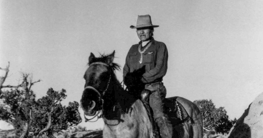 Vintage black-and-white photograph of a Diné horseman on horseback