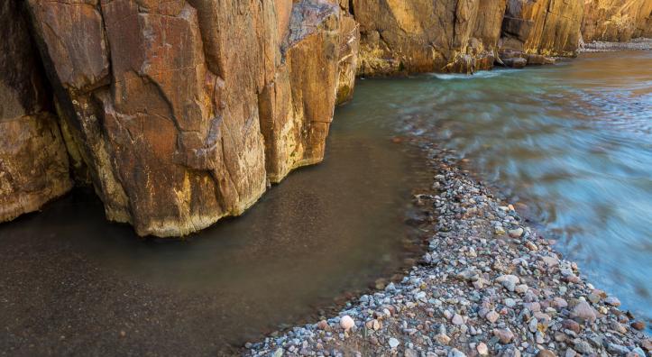 Cool water glides past warmly lit walls in Aravaipa Canyon. | Marc Strickland