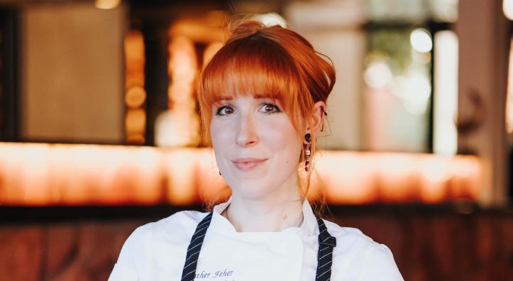 A red-headed chef displays a plate of grilled octopus in a dining room in Sedona. 