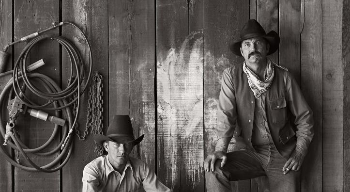 Black and white photo of cowboys Buster Scarbrough and Bob Pulley pose for a photo at the A Bar V Ranch in Skull Valley in 1981. This shot was one of several Jay Dusard photos published in the August 1982 issue of Arizona Highways. 