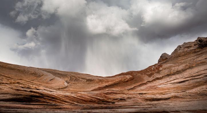 A sudden spring storm looms over the sandstone formations of White Pocket, part of Vermilion Cliffs National Monument north of the Grand Canyon. By Suzanne Mathia