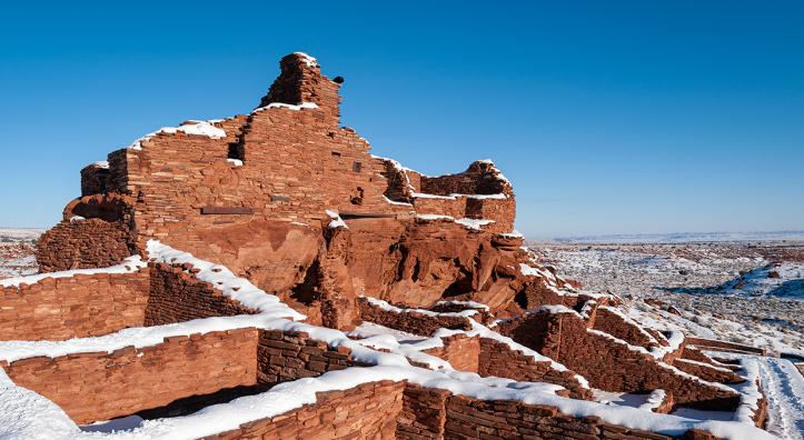 A raven and a fresh coat of snow adorn Wupatki Pueblo, the centerpiece of Wupatki National Monument. The pueblo is accessible via a short walk from the monument’s visitors center. By Elias Butler
