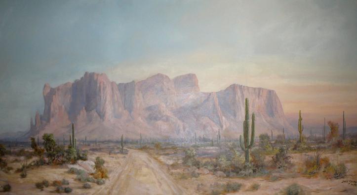 Superstition Mountain is the title of this painting by David Swing, depicting the iconic mountain with a foreground of a dirt road through desert landscape dotted by saguaros.