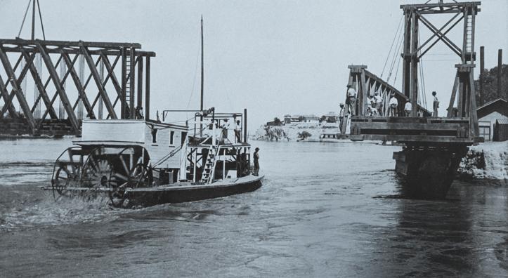 The gas-powered riverboat Aztec passes through a movable bridge at Yuma in 1902. The Aztec moved cargo on the Colorado River between Yuma and Needles, California, until 1905, when a severe sandstorm caused it to wreck a few miles downstream from Needles. | THE HUNTINGTON LIBRARY