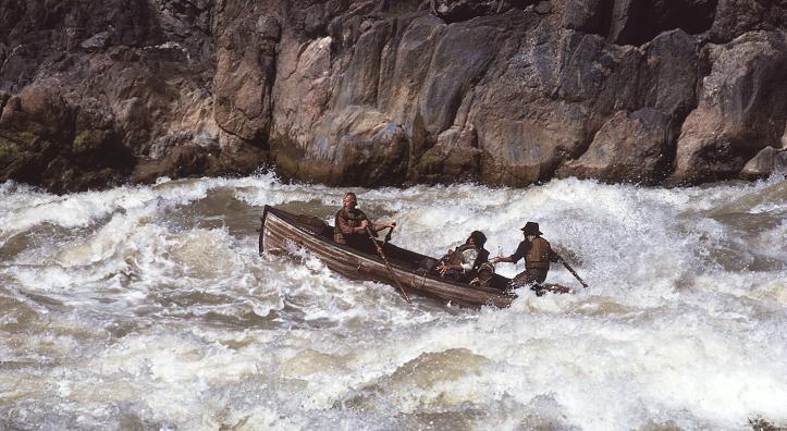 Bruce Simballa (on oars) and Kenton Grua (steering) guide an authentic Whitehall boat, the kind used by John Wesley Powell’s party, through the Grand Canyon’s Granite Rapids for an Imax film in 1984. Powell’s group portaged these rapids, but modern boatmen have the skills and experience to run these boats through the Canyon’s largest rapids. By Rudi Petschek