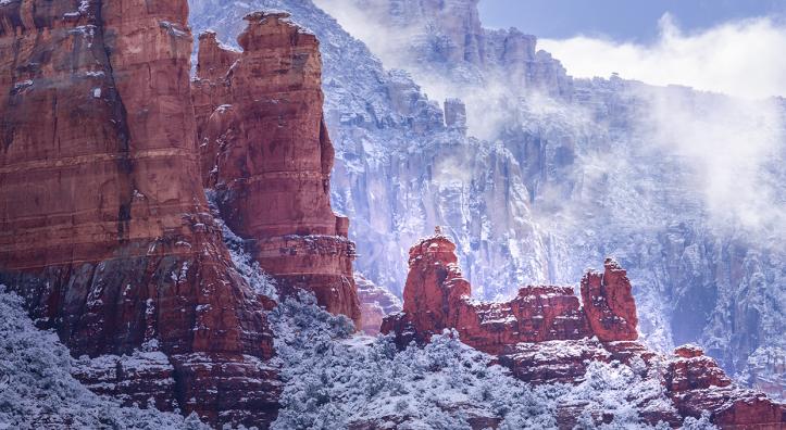 Fog and snow-covered foliage combine to form a wintry scene amid the sandstone buttes of Red Rock Country. The formations seen in the foreground are part of Snoopy Rock, named for its resemblance to the Peanuts character. | Larry Lindahl