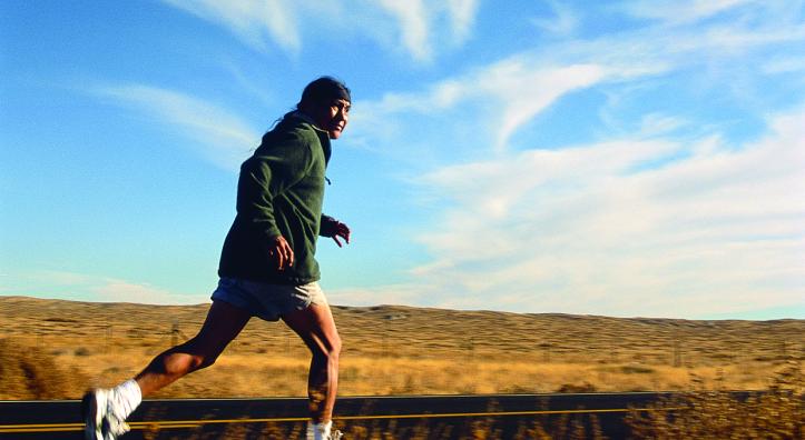 pounding the road  Dale Jackson runs along the road between the Hopi village of Moenkopi and Dilkon, on the Navajo Indian Reservation, during a 100-mile training relay. Shadows form in the red rock badlands (right) on the Hopi Indian Reservation. | Gary Johnson