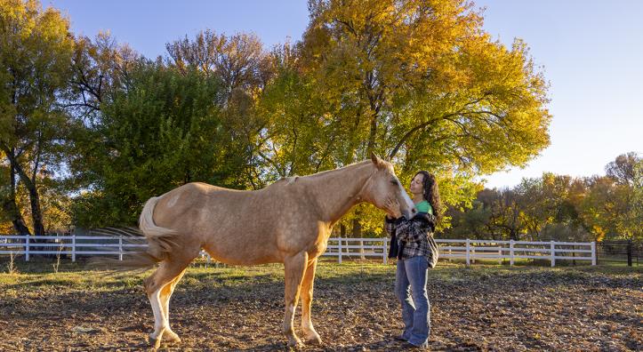 Joanne Cacciatore lovingly cradles the contented face of Chemakoh, a tan rescue horse, at Selah Carefarm, near Sedona. By John Burcham