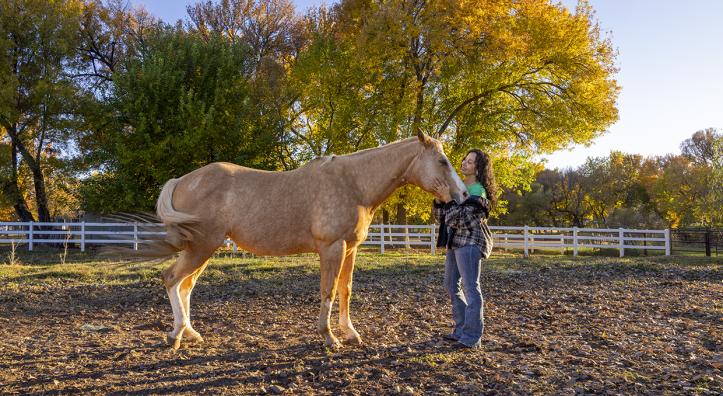 Joanne Cacciatore lovingly cradles the contented face of Chemakoh, a tan rescue horse, at Selah Carefarm, near Sedona. By John Burcham