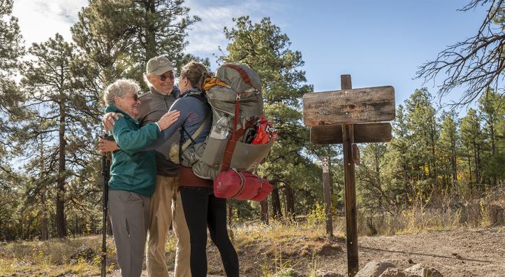 Arizona Trail thru-hiker Melina Keil, visiting from Germany, embraces “trail angels” Melody and Tim Varner on the trail near Flagstaff. Keil reached out to the Varners just a day before she was to arrive, and the couple sprang into action. | Dawn Kish