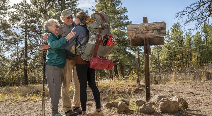 Arizona Trail thru-hiker Melina Keil, visiting from Germany, embraces “trail angels” Melody and Tim Varner on the trail near Flagstaff. Keil reached out to the Varners just a day before she was to arrive, and the couple sprang into action. | Dawn Kish