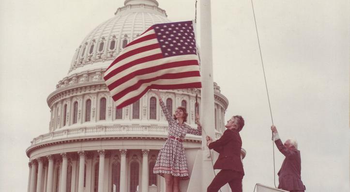 On June 14, 1976, Carolyn Hartmann (left) and Associate Editor Wes Holden (center) flew an American “flag rug” over the U.S. Capitol.