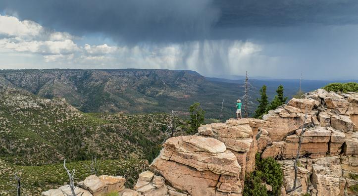Writer Tyler Williams surveys a significant  rainstorm from the Mogollon Rim, east of Baker Butte. There, the Rim and the Arizona Divide make a sharp turn toward the east. | John Burcham