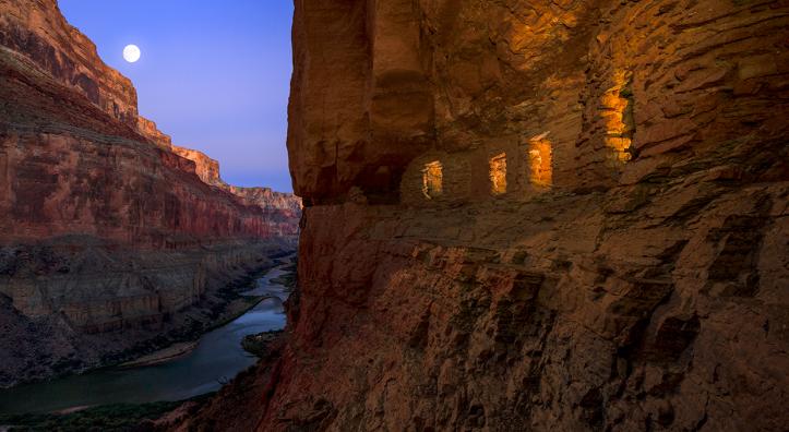 Light spills out of the Nankoweap granaries as the moon rises over the Colorado River at the Grand Canyon. | Adam Schallau