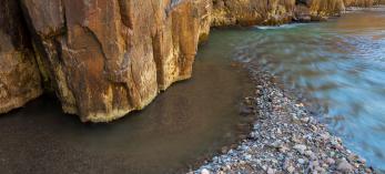 Cool water glides past warmly lit walls in Aravaipa Canyon. | Marc Strickland