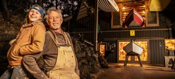 Two boatbuilders in front of their shop