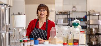 Melody Frazer in community kitchen with cooking ingredients. Photograph by John Burcham.