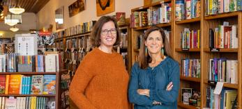 Lisa Lamberson and Annette Avery in front of bookshelves at their shop. Photograph by John Burcham.