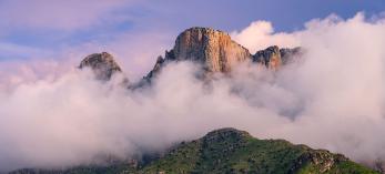  Low-hanging storm clouds cloak the cliffs of the Pusch Ridge Wilderness in the Santa Catalina Mountains, near Tucson.  By Jack Dykinga