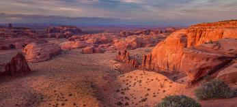 Shadows cloak the sandstone buttes of Monument Valley in a sunset view from Hunts Mesa. By Larry Lindahl