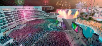 A brightly colored rendering depicts a massive amphitheater with a flame pit, fireworks and bright lights