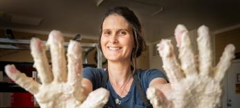 Rachelle Wingfield shows off doughy hands for the camera at her bakery. By Dawn Kish