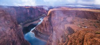 Fog and mist lift from Glen Canyon, revealing the sky reflected in the water below. By Gary Ladd