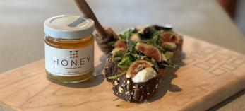 A color image shows a small jar of honey and two bite-sized snacks with fig, honey and cheese.
